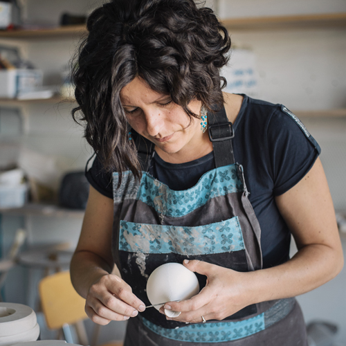 Noëlla Staykov, céramiste, façonne une décoration de Noël en porcelaine dans son atelier