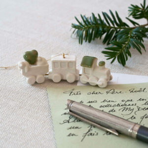 Petit train en porcelaine posé sur une lettre au Père-Noël manuscrite